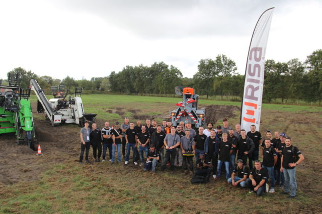 Photo de toute l'équipe de production de l'usine RISA, au salon LE DIG TOUR de Bordeaux en 2022. Au DIG TOUR, RISA exposait des trancheuses RT200 et RT300VS, spécialisées dans la pose de réseaux souterrains de fibre, gaz, eau et électricité (haute tension HTA et basse-tension), ainsi que des grues de forage lève-poteaux CHALLENGER et KPL et sur UNIMOG, spécialisés dans la pose de réseaux aériens.