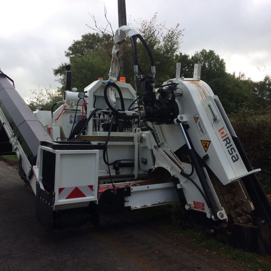 Trancheuse RISA RT170 avec système d'outil de coupe à flèche coulissante spécialisée dans la pose de réseaux souterrains, fibre et électricité. Client LABRUX Travaux Publics. Moteur CUMMINS 6 cylindres turbo de 170 chevaux, convoyeur latéral pour chargement des matériaux dans un camion et radiocommande / télécommande pour commande de l'ensemble des fonctions hydrauliques et électroniques de la machine à distance.